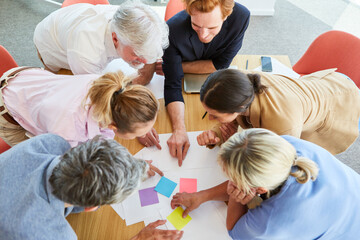 Business professionals discussing over documents and sticky notes during meeting in conference room