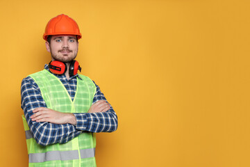 Wall Mural - Engineer in helmet on yellow background, space for text