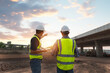 © somchai20162516 - The chief civil engineer is introducing inspection of a road or expressway construction project under the road to an intern. At the expressway construction site
