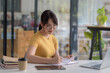© amnaj - Young Asian Woman Studying with Laptop and Taking Notes for Online Learning