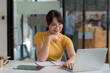 © amnaj - Young Asian Woman Studying with Laptop and Taking Notes for Online Learning