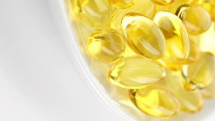 Wall Mural - Yellow softgel capsule Vitamins Omega 3 or fish oil in white plate, rotate. Vertical video