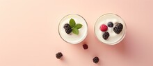 Front View Of Macro Shot Of Wild Berry Topped White Yogurt In Two Glasses On A Isolated Pastel Background Copy Space