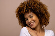 © WavebreakMediaMicro - Biracial woman with curly hair, smiling with hand on shoulder