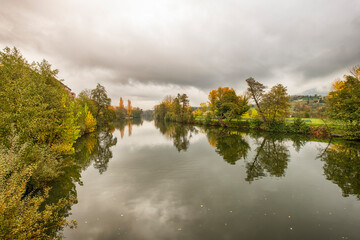 Landscape of the Jerte River as it passes through the city of Plasencia during autumn with the leaves of the trees showing off their beautiful colors.