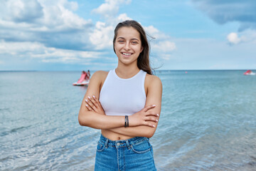 Wall Mural - Portrait of smiling teenage girl outdoor on sea background