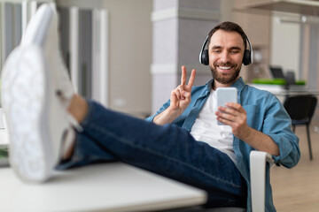 Poster - Cheerful Young Man Making Video Call On Smartphone In Office