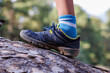© zhukovvvlad - Close-up child's feet walk along the log of a fallen tree. a child in sneakers walks on a fallen tree. camping in the woods.