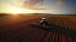 Sunset Fieldwork: Aerial View of Modern Tractor Plowing, Showcasing Advanced Farming Technology.