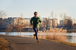 © baranq - Adult man running in urban environment during autumn or winter