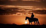 Fototapeta Konie - Cowboys on horseback at sunset