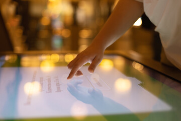 A woman uses an interactive touch screen display at a trade show, searching for information. The concept of education, entertainment and technology