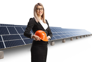 Poster - Businesswoman holding a helmet in front of photovoltaic panels