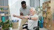 © Nina L/peopleimages.com - Senior man with disability, physiotherapist and stretching band for muscle rehabilitation, chiropractor service or help. Physical therapy, medical support or patient in wheelchair at recovery clinic
