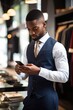 © Alfazet Chronicles - cropped shot of a young businessman using his cellphone while working in his store