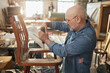 © Seventyfour - Side view portrait of senior man repairing old furniture in carpentry workshop, copy space