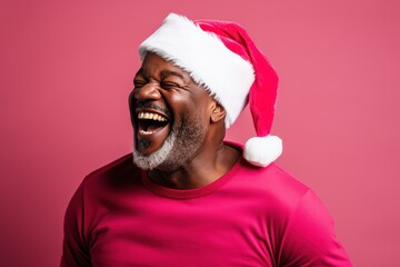 Wall Mural - Dark-skinned man wearing a Santa Claus hat on a red background.