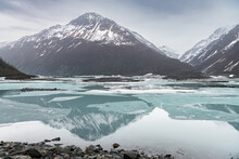 Snow Covered Mountains Reflected Between The Ice Sheets In Valdez Glacier Lake, Valdez, Alaska, USA