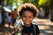 Draught in Africa, lack of clean water, world's global warming problem concept. Bottle of pure fresh drinking water in hand of thirsty happy little afro-american child. 