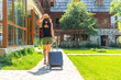 © unai - Tourist woman with a suitcase on rural vacation arriving at a mountain cabin