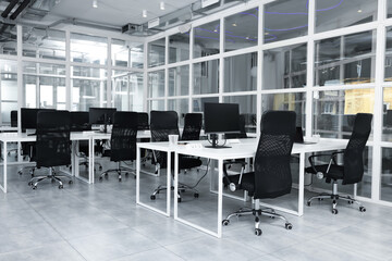 Wall Mural - Stylish interior of open plan office. Workspace with computers, tables and chairs