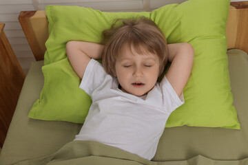 Sticker - Little boy snoring while sleeping in bed at home, above view