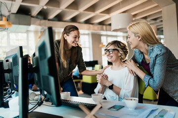 young and diverse group of women working together in a startup company office