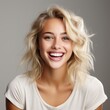 portrait of a beautiful young blonde model woman laughing and smiling with clean teeth