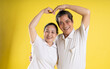 © 1112000 - portrait of middle aged asian couple posing on yellow background