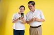 © 1112000 - portrait of middle aged asian couple posing on yellow background