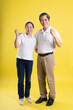 © 1112000 - portrait of middle aged asian couple posing on yellow background