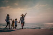 © Day Of Victory Stu. - Happy Asian family consisting of father, mother, Son and daughter having fun playing on the beach.