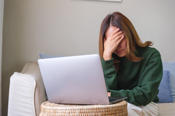 Canvas Print - A woman get headache and stressed while working online on laptop computer at home