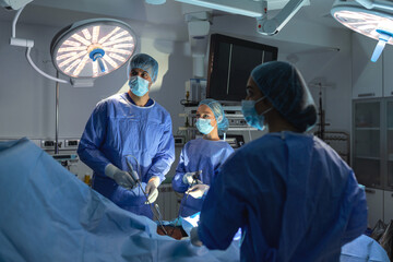 Wall Mural - Three surgeons doing laparoscopic surgery. Doctors looking at image on monitor. Medicine and healthcare concept. Internal organ of patient seen on computer monitor