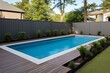 A rectangular pool with a fence and tan edges in a backyard of a new house. Generative AI