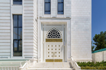 Wall Mural - White carved antique wooden doors with patterns, golden metal jewelry and mosaics.