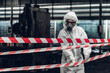 © kanpisut - Scientist wear Chemical protection suit check danger chemical, working at dangerous zone in Red and White Lines of barrier tape. Red and white Hazardous restricted area factory safety worker industry