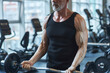 © Westend61 - Strong mature man strengthening arms with barbell in gym