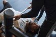 © Westend61 - Young man doing bench press with help of trainer in health club
