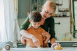 © Westend61 - Mother and son cutting dough with cookie cutter in kitchen