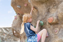 Girl Climbing Rocks Wall On Playground