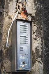 Old vintage intercom on a weathered old building- entrance to an old house with many appartements