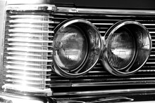 Close-up Of The Round Headlamps Of A Black And White American Classic Car. 