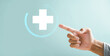 © sorapop - Signifies health, medicine, and insurance safeguarding family business. Plus icon touched by hand, drawing focus to healthcare impact. Showcases hospital access and welfare health service growth.