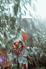 Poster - mad evil clown seen through the branches of a tree