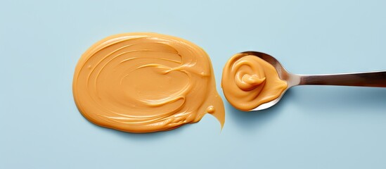 Poster - Peanut butter on a spoon against isolated pastel background Copy space American morning delight