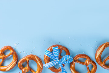 Wall Mural - Oktoberfest background with bavarian pretzels and checkered ribbon tied with bow