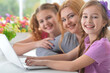 © aletia2011 - Mother and girls sitting at table and using laptop