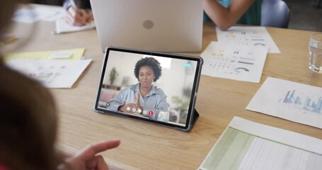 Poster - Caucasian businesswoman on tablet video call with african american female colleague on screen