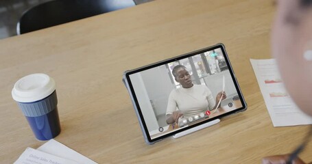 Poster - Caucasian businesswoman on tablet video call with african american male colleague on screen